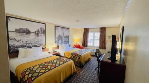 a hotel room with two beds and a television at Super 8 by Wyndham Maumee Perrysburg Toledo Area in Maumee