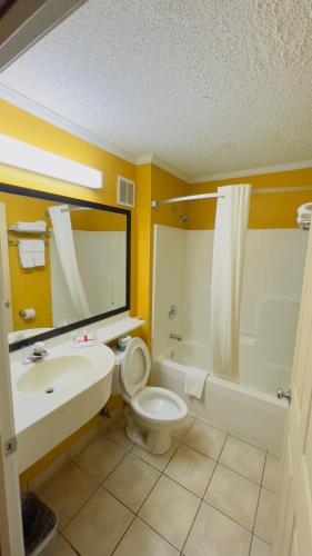 a bathroom with a sink and a toilet and a tub at Super 8 by Wyndham Maumee Perrysburg Toledo Area in Maumee