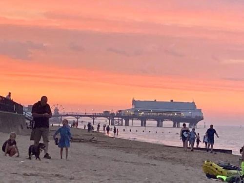 a group of people on the beach at sunset at Seafront Luxury Apartment in Cleethorpes