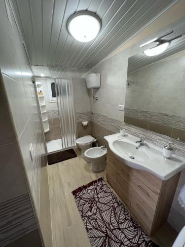 a bathroom with a sink and a toilet and a mirror at Casa Vacanze Desiderio in Nebida