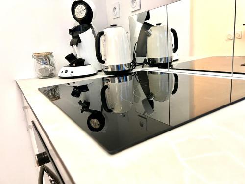 a kitchen with a glass counter top with a coffee maker at les suites du beffroi 2 in Calais