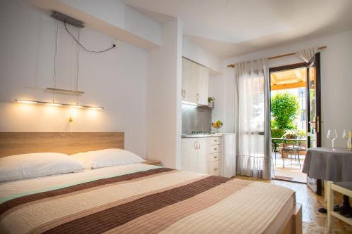a bedroom with a bed and a table and a kitchen at Studio LUKA in Rovinj