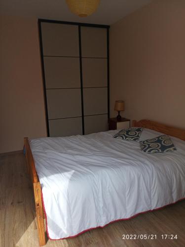 une chambre avec un grand lit avec des draps blancs dans l'établissement Maison les Mathes, aux Mathes