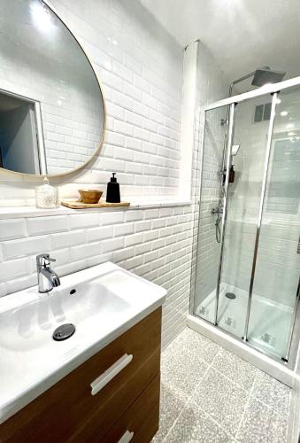 a white bathroom with a sink and a shower at les suites du beffroi in Calais