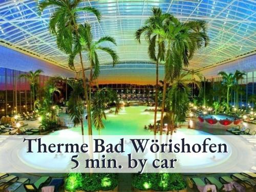 a large indoor mall with palm trees and a ceiling at Schicke Ferienwohnung in bester Lage mit Sonnenbalkon l Innenstadtnähe l 1 Minute zum Bahnhof l Küche l Großer Schreibtisch l TV l Free-WLAN l Willkommen im Hallo!-Apartment 13 in Bad Wörishofen