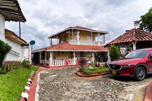 een rode auto geparkeerd voor een huis bij Casa Campestre La Colombiana in Montenegro