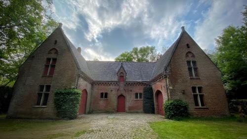 un gran edificio de ladrillo con 2 ventanas grandes en SENSI - 'FIRE' Restaurant and Glamping en Oostkamp