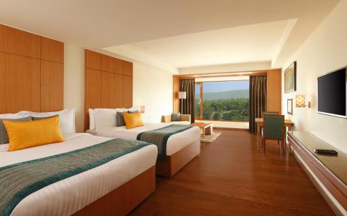 a hotel room with two beds and a flat screen tv at Lemon Tree Hotel, Dehradun in Dehradun