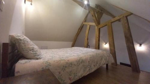 um quarto com uma cama com uma estrutura em madeira em logement indépendant em Tour-en-Sologne