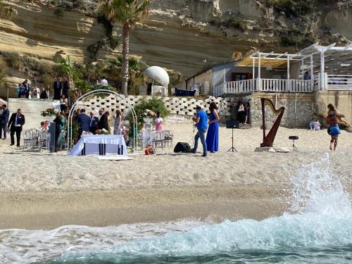 a group of people standing on a beach at Oldwell Hotel in Santa Domenica