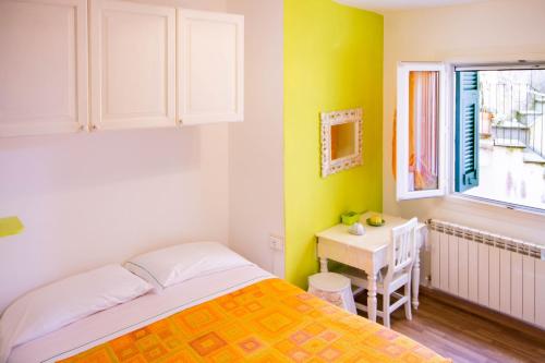 ヴェルナッツァにあるsolemagia in via romaのベッドルーム1室(ベッド1台、デスク、窓付)