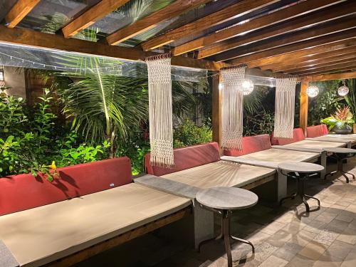 a row of benches in a restaurant with plants at Villa Sapê Pousada in Ubatuba