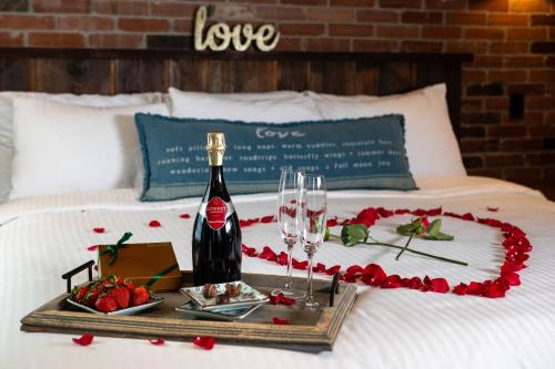 a tray with a bottle of wine and glasses on a bed at The Barnstead Inn in Manchester Center