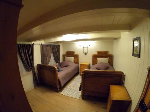 ein kleines Zimmer mit 2 Betten und 2 Stühlen in der Unterkunft Mountain peace in the heart of Switzerland in Emmetten