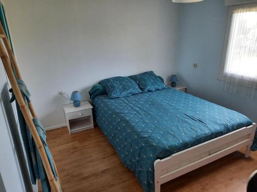 1 dormitorio con 1 cama con edredón azul en Chambres tranquilles en campagne, en Éancé