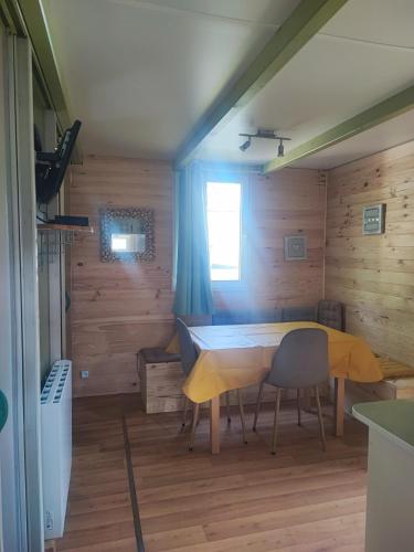 une salle à manger avec une table et deux chaises dans l'établissement les chalets de l'essentiel, à Lacaze