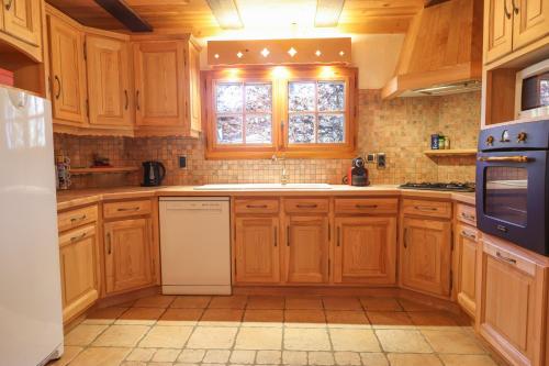 une cuisine avec des armoires en bois et une fenêtre dans l'établissement Chalet Belle-Sofianna, à Saint-Gervais-les-Bains