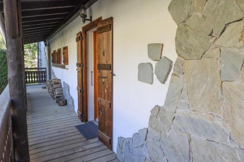 um edifício com uma porta de madeira e uma parede de pedra em Chalet Belle-Sofianna em Saint-Gervais-les-Bains