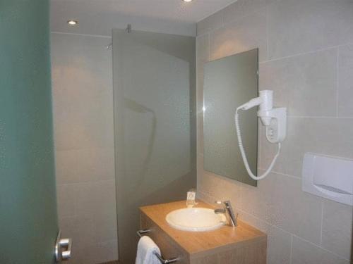 a bathroom with a sink and a shower at Hotel Biederstein am Englischen Garten in Munich