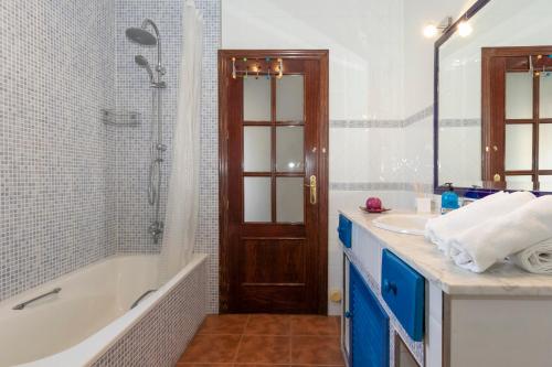 a bathroom with a tub and a sink and a shower at Casa de la Vega in Cúllar-Vega