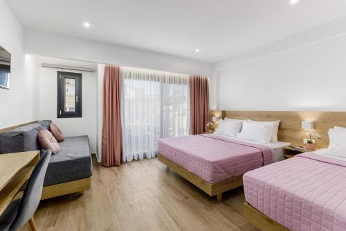 a hotel room with two beds and a couch at Anassa Suites in Leptokaria