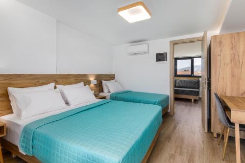 a hotel room with two beds and a desk at Anassa Suites in Leptokaria