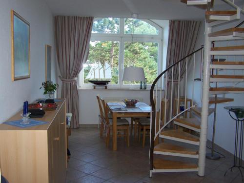 a kitchen and dining room with a table and a spiral staircase at Meerblick Heringsdorf in Heringsdorf