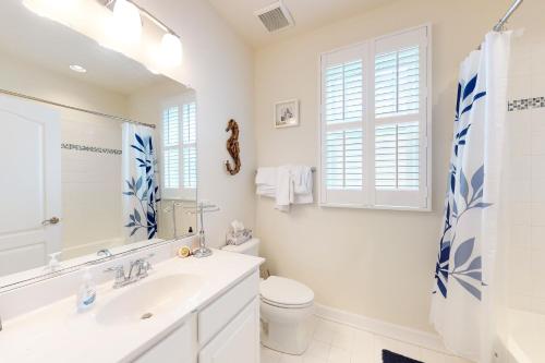 a white bathroom with a sink and a toilet at Millville by the Sea- 23923 Pembroke Lane in Millville