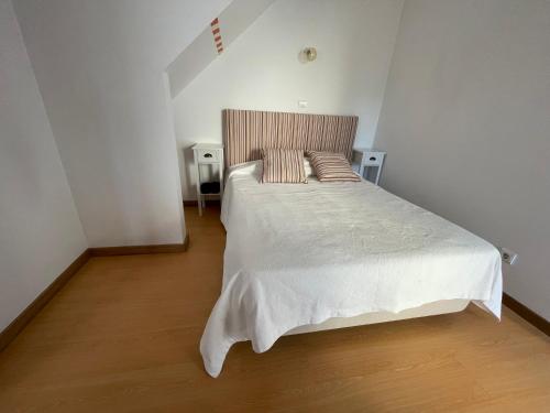 a bedroom with a large white bed with two pillows at A QUINTA DAS FLORES- Casa do Miradouro in Santa Cruz das Flores