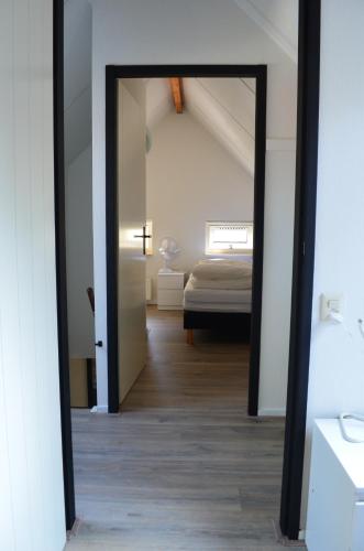 een spiegel in een hal met een bed in een kamer bij wittebergen25 in IJhorst