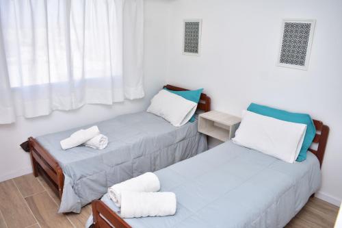 - 2 lits jumeaux dans une chambre avec fenêtre dans l'établissement la mas linda ventana al mar, à Puerto Madryn