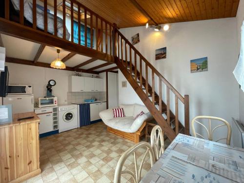 un salon avec un escalier et une cuisine dans l'établissement Appartement Cosy avec Terrasse Intime, à 500m de la Plage de Nauzan - FR-1-550-37, à Vaux-sur-Mer