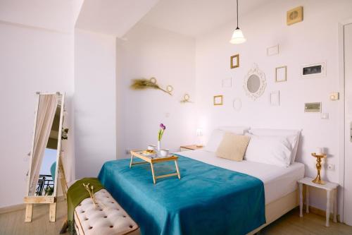 a bedroom with a bed with a blue blanket and a table at Breathless Sea Studio in Rethymno Town