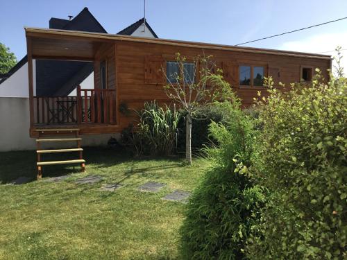 eine Blockhütte mit einer Veranda und einer Terrasse in der Unterkunft Sci Ti Korelo in Guidel