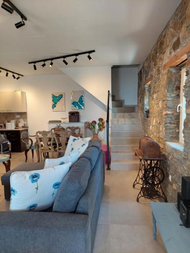 a living room with a couch and a stone wall at Villa Johell in Neos Marmaras