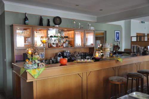 a bar with a wooden counter and stools in a room at Hotel Elxleben in Elxleben