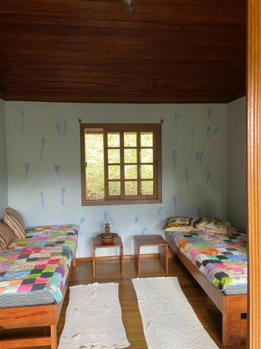 two beds in a room with a window at Monte Carmelo Inn Sana in Sana