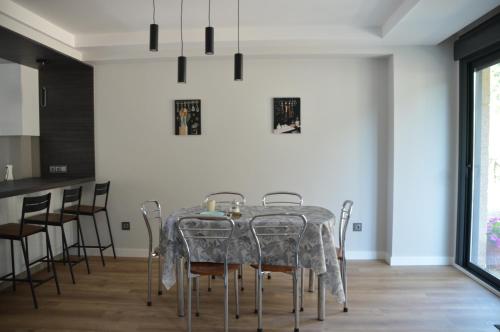 a dining room with a table and chairs at Casa da Rabeira con terraza barbacoa y aparcamiento in Cambados