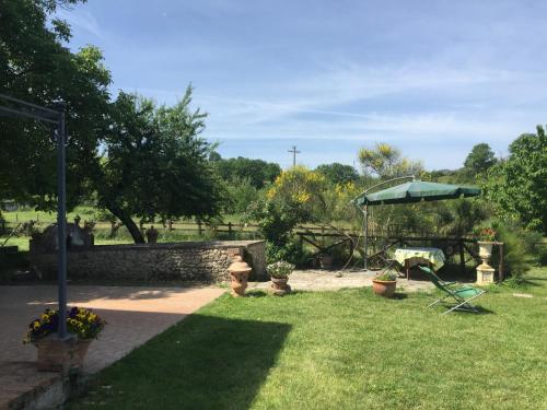 einen Garten mit einem Tisch und einem Sonnenschirm in der Unterkunft Casale delle ginestre. in Castel Madama