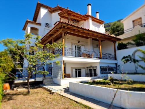 Una casa blanca con un balcón en el lateral. en The Mirador Boutique Villa with Scenic Sea View, en Porto Rafti