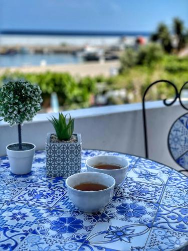 a table with two bowls of coffee on a blue and white table cloth at Seaview apartment in Tsoútsouros