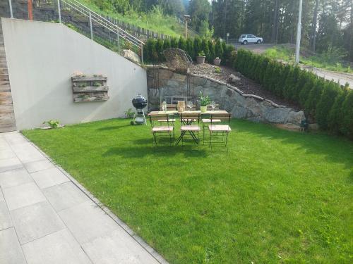 a garden with a table and chairs on the grass at Appartement Naturnah in Mieders