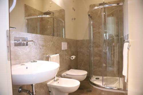 La salle de bains est pourvue d'un lavabo, de toilettes et d'une douche. dans l'établissement DIMORE MORELLI, à Amantea