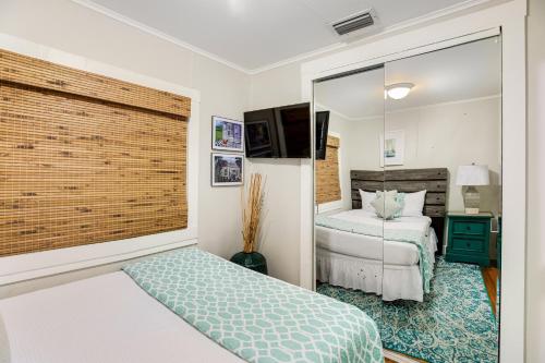 a small bedroom with a bed and a mirror at Tropic Dream in Key West