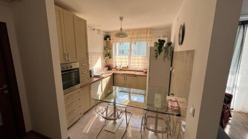 a kitchen with a glass table and a refrigerator at Sunrise apartment in Bistriţa