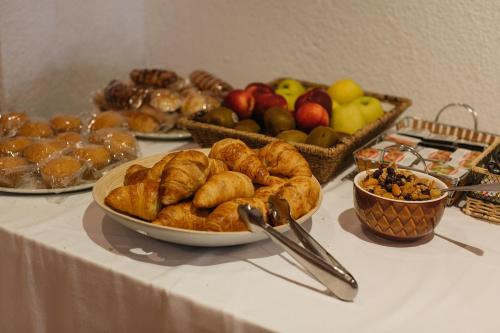 a table topped with pastries and fruits and other foods at Mallorca Boutique Hotel in Malgrat de Mar