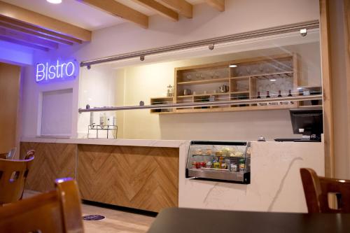 a restaurant with a counter with an open refrigerator at Hotel Mesaluna Near American Consulate in Ciudad Juárez