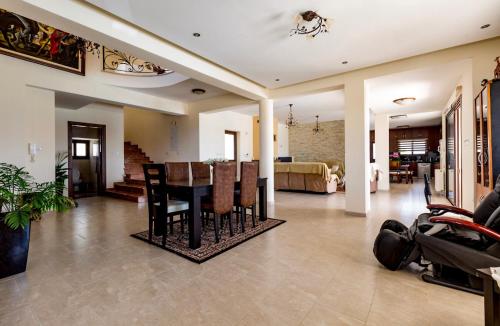 a dining room and living room with a table and chairs at SunShine Villa Paphos in Nicosia