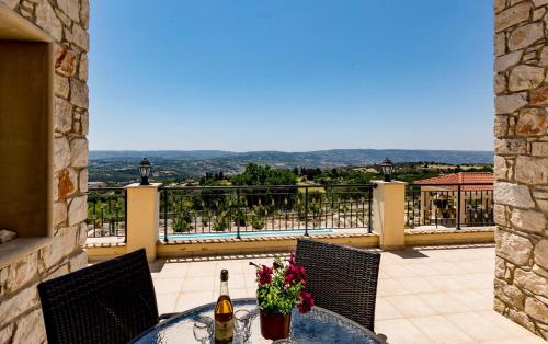 a table with a bottle of wine and flowers on a balcony at SunShine Villa Paphos in Nicosia