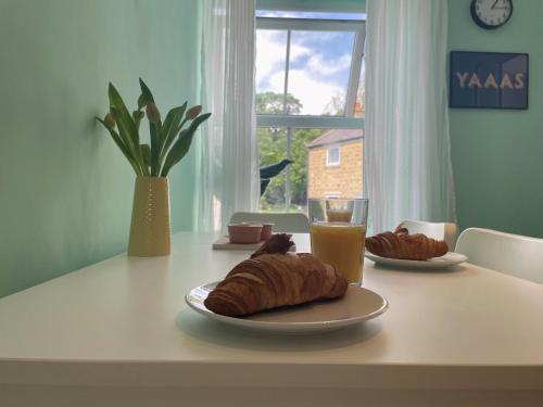 a table with a plate of croissants and a glass of orange juice at 2-Bed Flat in Summerbridge Harrogate Pet Friendly in Harrogate